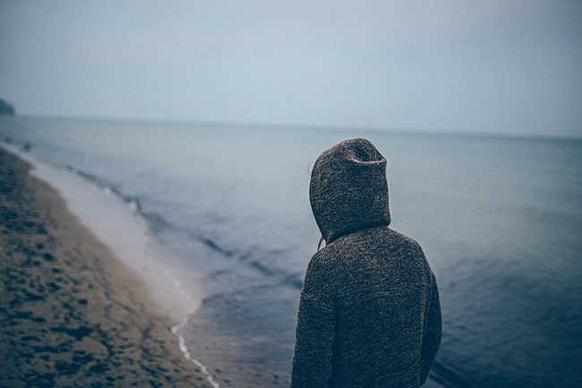 loneliness Generation Z woman walking alone beach
